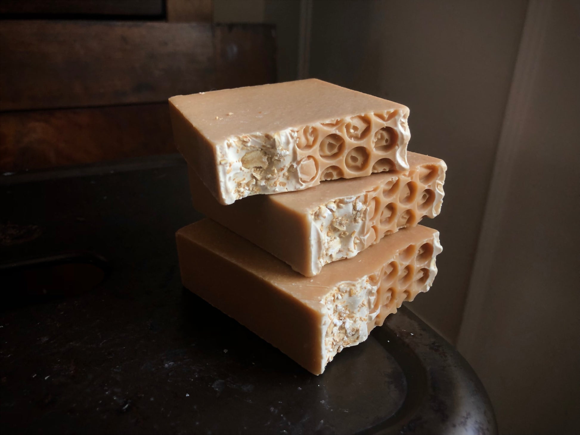three bars of tan soap with honeycomb top on metal stool